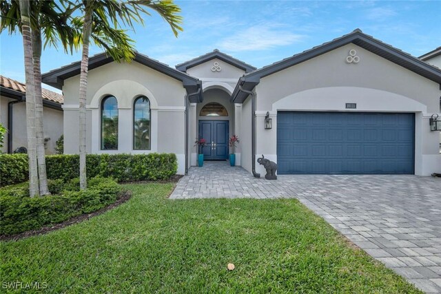10111 Palazzo Dr, Naples, FL 34119 - view of front facade with stucco siding, a front yard, an attached garage, and decorative driveway