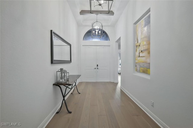10111 Palazzo Dr, Naples, FL 34119 - foyer entrance with wood finished floors, baseboards, a chandelier, a tray ceiling, and a high ceiling