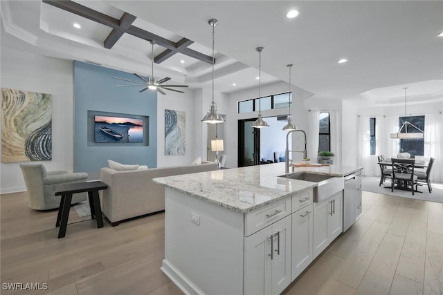 10111 Palazzo Dr, Naples, FL 34119 - kitchen featuring a sink, light wood finished floors, open floor plan, white cabinetry, and coffered ceiling