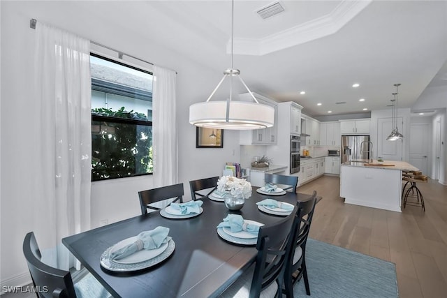 10111 Palazzo Dr, Naples, FL 34119 - dining room featuring light wood-type flooring, recessed lighting, a tray ceiling, and ornamental molding