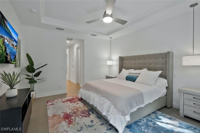 10111 Palazzo Dr, Naples, FL 34119 - bedroom with a raised ceiling, crown molding, wood finished floors, ceiling fan, and baseboards