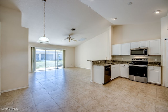 kitchen with open floor plan, decorative backsplash, appliances with stainless steel finishes, white cabinets, and a sink