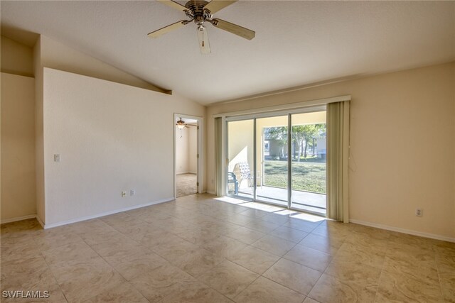 empty room featuring lofted ceiling, baseboards, and ceiling fan