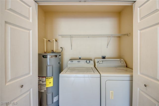 washroom featuring electric water heater, laundry area, and washer and clothes dryer