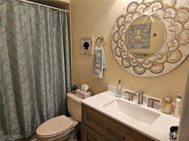 bathroom featuring curtained shower, toilet, and vanity