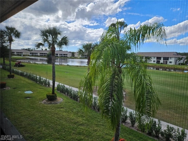 view of property's community with a yard and a water view