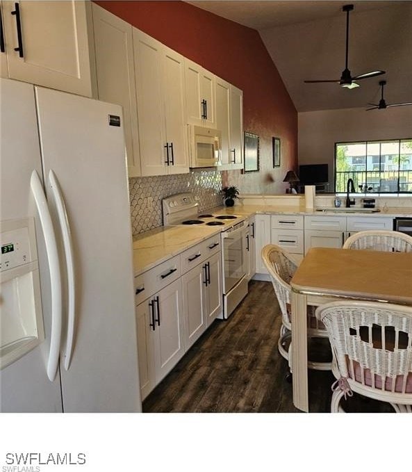 kitchen featuring white cabinetry, white appliances, dark wood-style flooring, and lofted ceiling