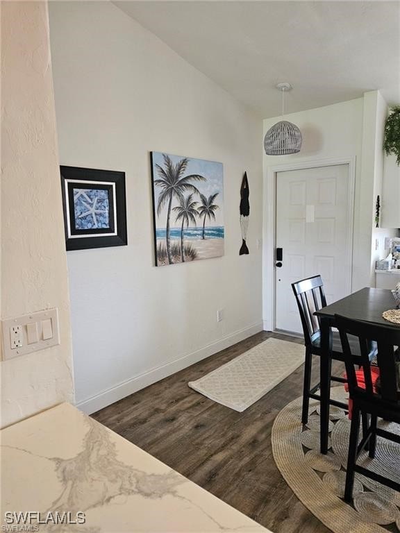 dining area featuring dark wood-style floors and baseboards