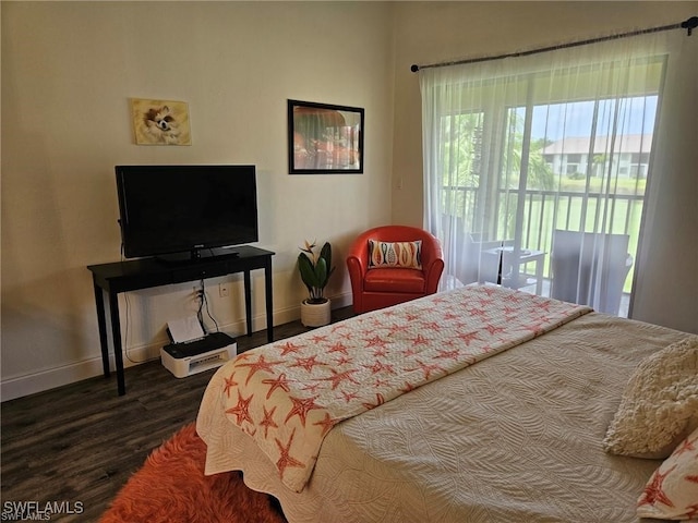 bedroom featuring access to outside, wood finished floors, and baseboards