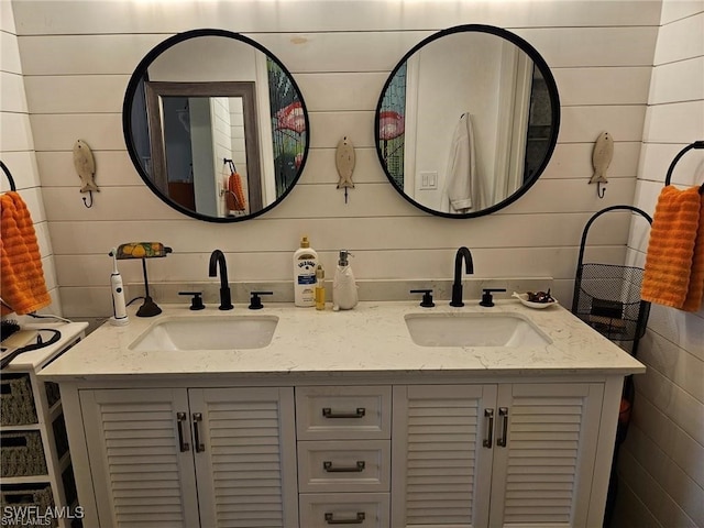 full bathroom with double vanity, tile walls, and a sink