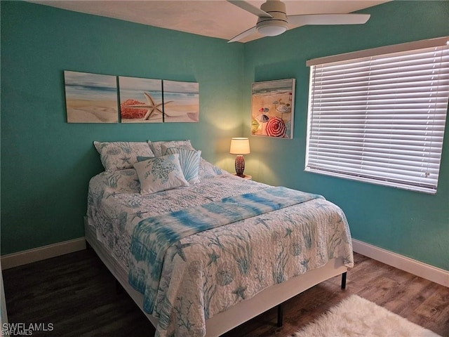 bedroom with a ceiling fan, baseboards, and wood finished floors