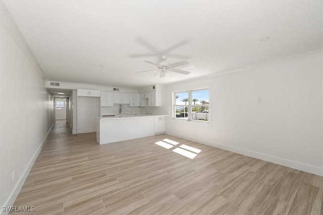 unfurnished living room with visible vents, baseboards, light wood-style floors, and a ceiling fan