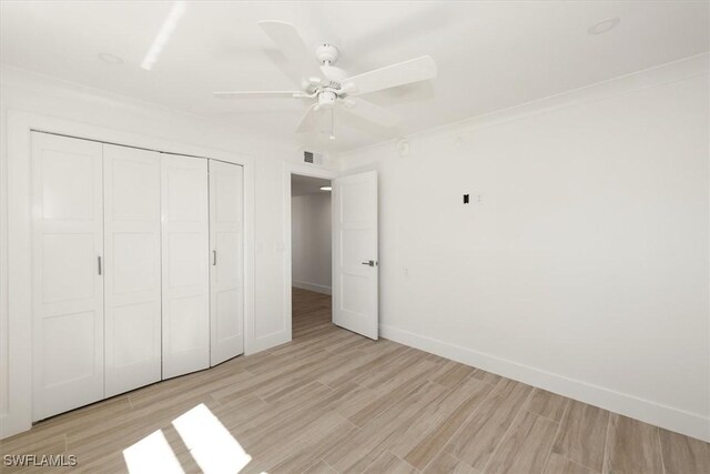 unfurnished bedroom with light wood-type flooring, visible vents, a closet, baseboards, and ceiling fan