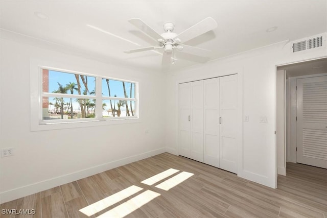 unfurnished bedroom featuring light wood finished floors, visible vents, a closet, and baseboards