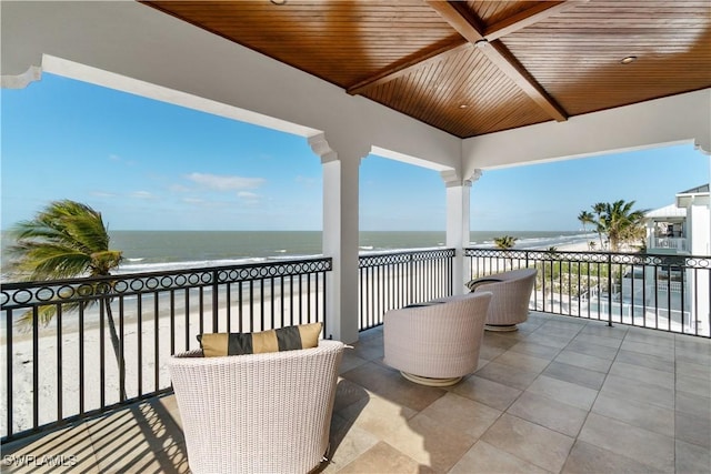 balcony with a water view and a beach view