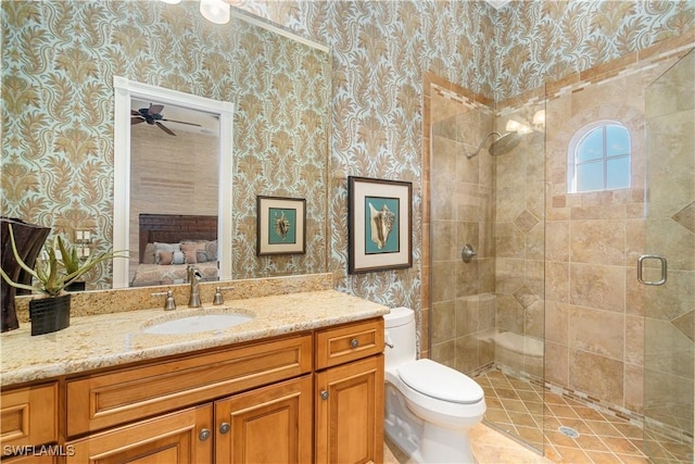 full bathroom with vanity, wallpapered walls, a shower stall, ensuite bathroom, and toilet