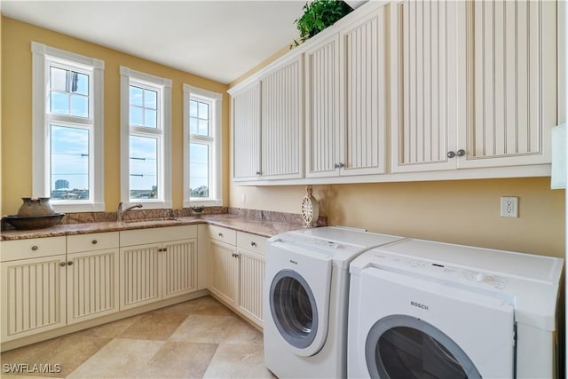 laundry room with washer and dryer, cabinet space, and a sink