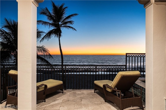 view of patio / terrace with a balcony and a water view