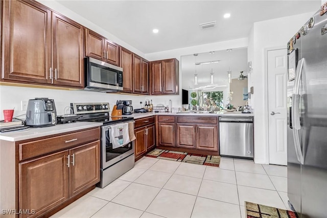 kitchen featuring light tile patterned floors, visible vents, a sink, stainless steel appliances, and light countertops