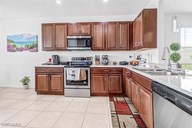 kitchen featuring a sink, stainless steel appliances, light countertops, and light tile patterned floors