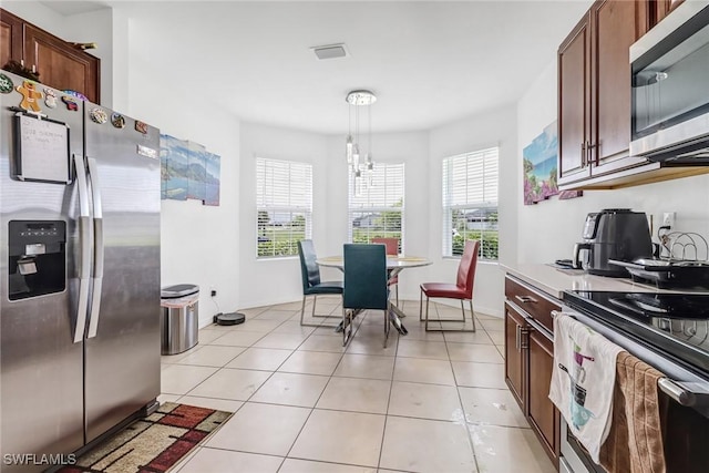 kitchen with visible vents, appliances with stainless steel finishes, light countertops, light tile patterned floors, and hanging light fixtures