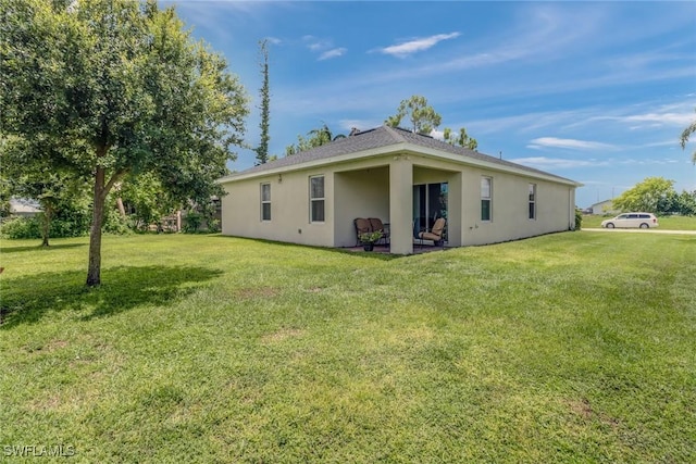 rear view of property with stucco siding and a lawn