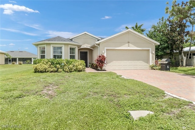 single story home with a front lawn, decorative driveway, an attached garage, and stucco siding