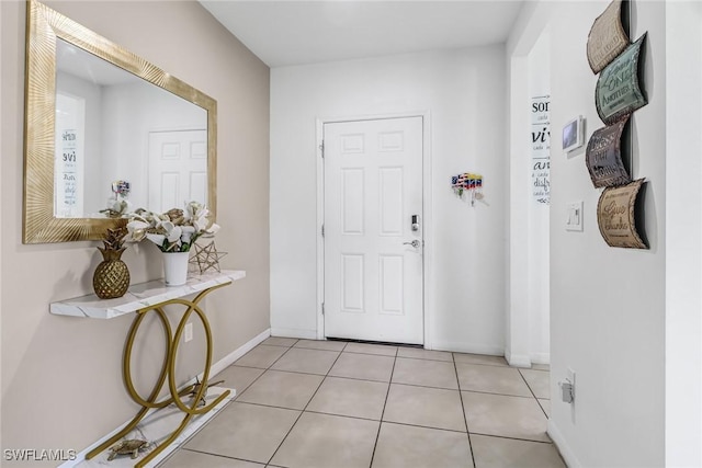 entryway with light tile patterned floors and baseboards