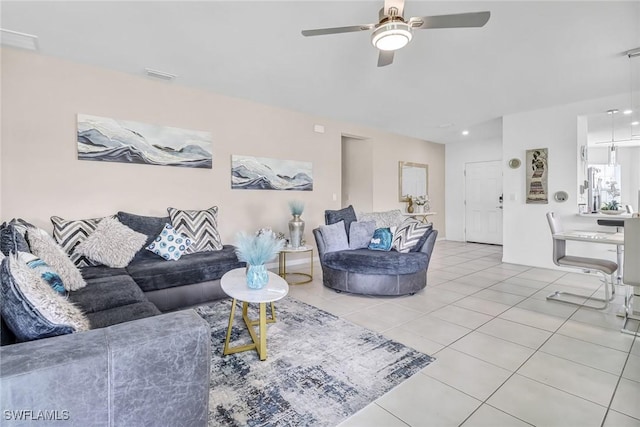 living room featuring light tile patterned floors, visible vents, and ceiling fan