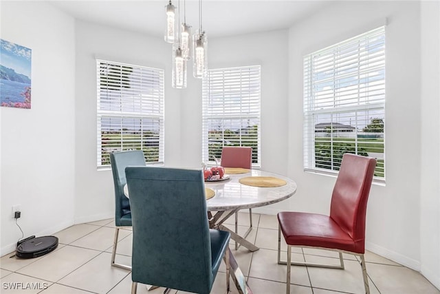 tiled dining room featuring baseboards