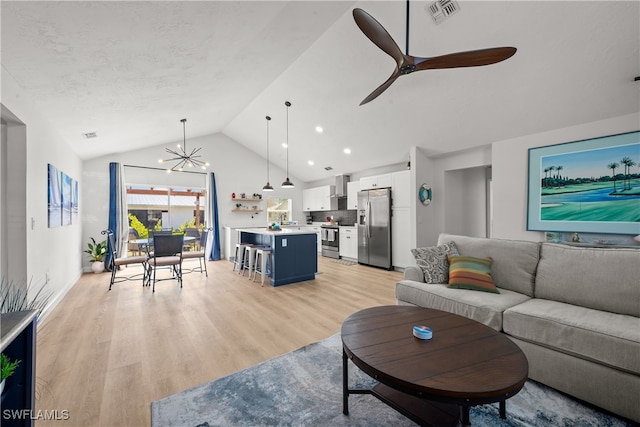 living room featuring visible vents, high vaulted ceiling, a textured ceiling, ceiling fan with notable chandelier, and light wood-type flooring