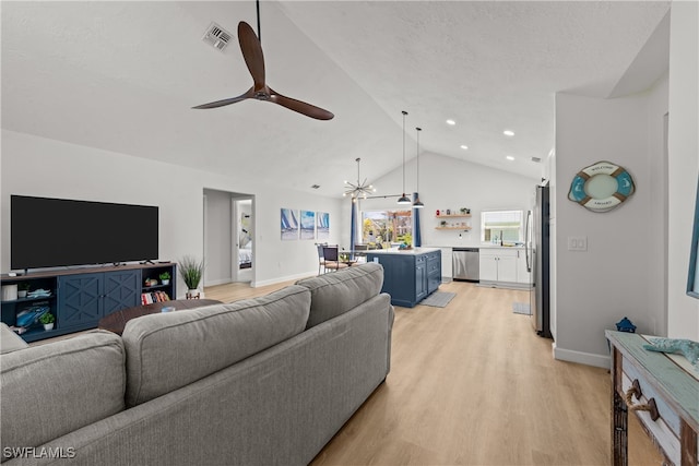 living area with ceiling fan with notable chandelier, visible vents, baseboards, and light wood-type flooring