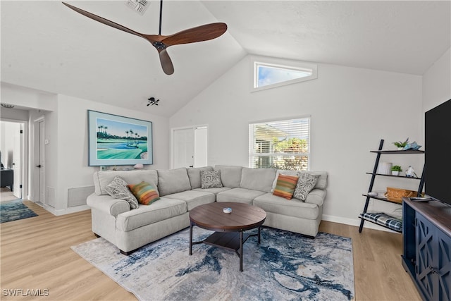 living room with visible vents, light wood finished floors, and high vaulted ceiling