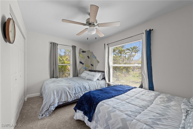 carpeted bedroom with a closet, baseboards, and a ceiling fan