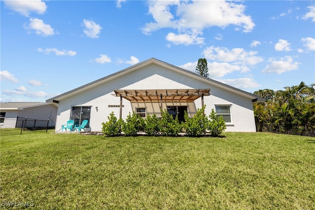 back of property with stucco siding, a yard, and a pergola