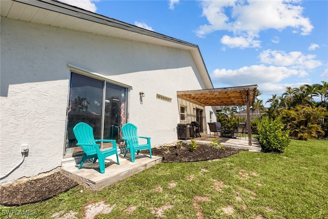 back of property featuring a yard, stucco siding, a pergola, and a patio