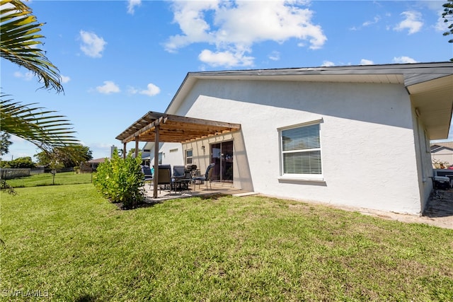 back of house with a lawn, fence, a patio, and stucco siding