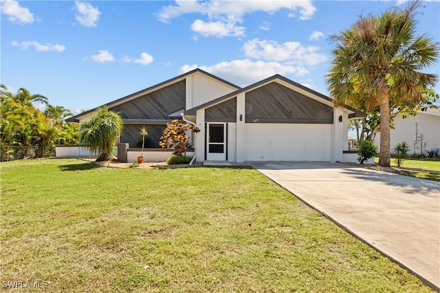 mid-century modern home with driveway, a front yard, a garage, and fence