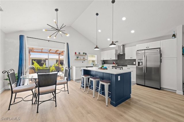 kitchen with open shelves, a kitchen island, stainless steel appliances, wall chimney exhaust hood, and white cabinets