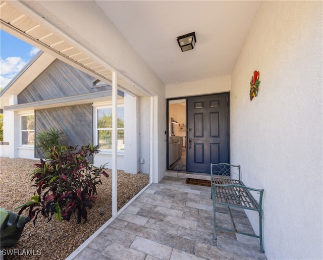 doorway to property featuring stucco siding