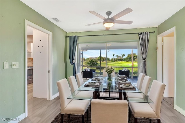 dining space with baseboards, visible vents, light wood finished floors, and ceiling fan