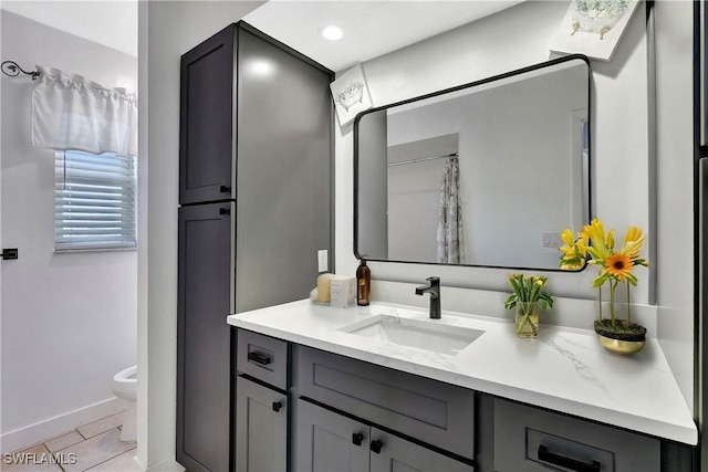 bathroom featuring vanity, tile patterned floors, toilet, and baseboards