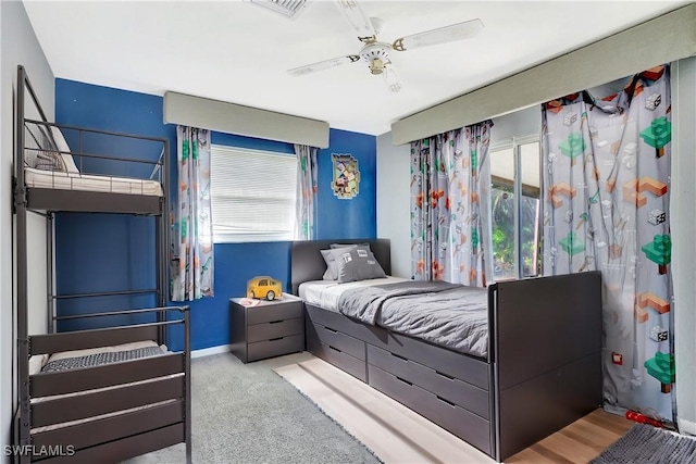 carpeted bedroom with visible vents, baseboards, and a ceiling fan