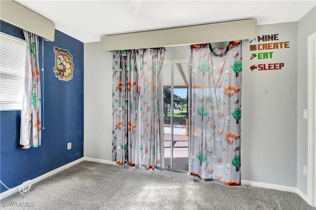 carpeted empty room featuring baseboards