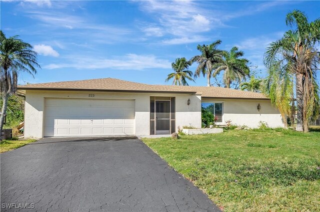 ranch-style house featuring a front lawn, an attached garage, driveway, and stucco siding