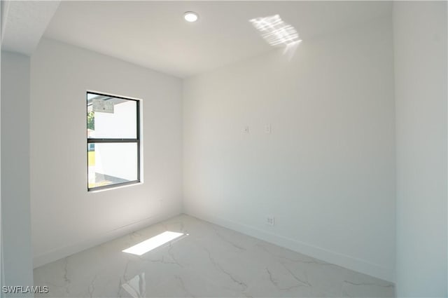 spare room featuring recessed lighting, baseboards, and marble finish floor