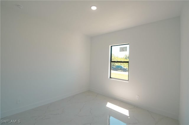 empty room with recessed lighting, marble finish floor, and baseboards