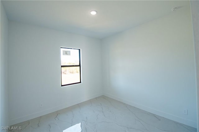 unfurnished room with recessed lighting, marble finish floor, and baseboards