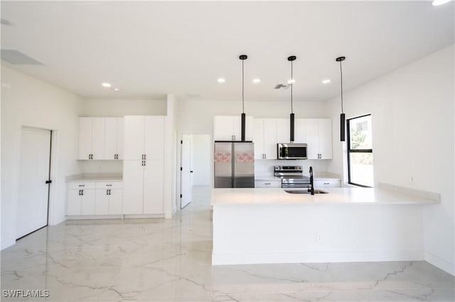 kitchen with light countertops, appliances with stainless steel finishes, white cabinets, marble finish floor, and a sink