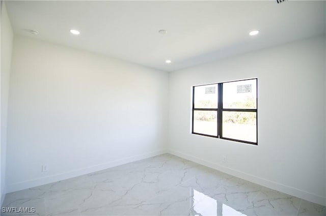 spare room featuring recessed lighting, baseboards, and marble finish floor